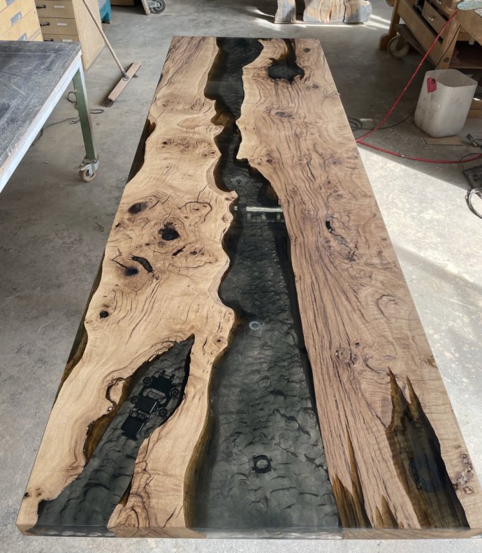 A table of 261 cm by 85 cm, solid oak, epoxy resin with inlays of metal parts